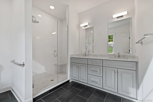 a bathroom with a shower sink and mirror