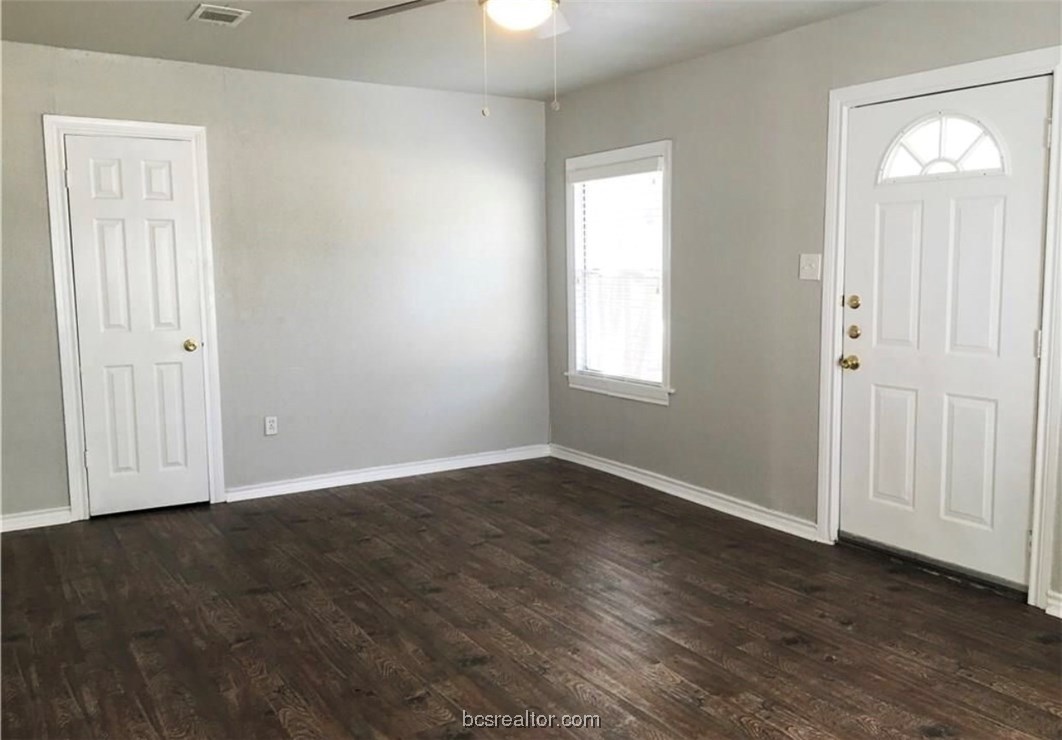 718 Edgewood Drive Bryan, TX 77802 - Photo 4 of 12 an empty room with wooden floor and windows