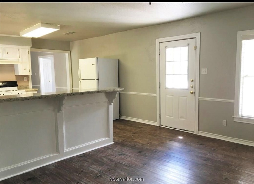 718 Edgewood Drive Bryan, TX 77802 - Photo 9 of 12 an empty room with wooden floor and windows