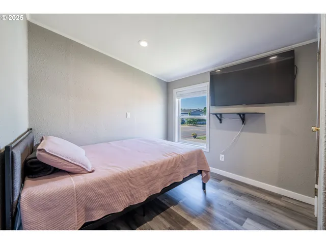 a bedroom with a bed and a flat screen tv