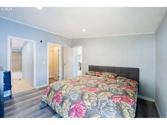 a bedroom with a bed and a painting on the wall