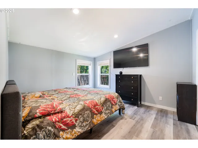 a bedroom with a bed and a flat screen tv