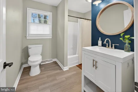 a bathroom with a toilet a sink and a mirror