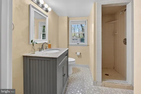 a bathroom with a sink a toilet and shower