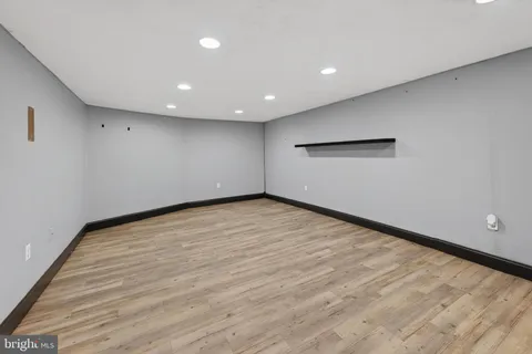 an empty room with wooden floor and natural light