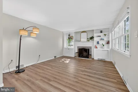 a view of a livingroom with wooden floor and a fireplace