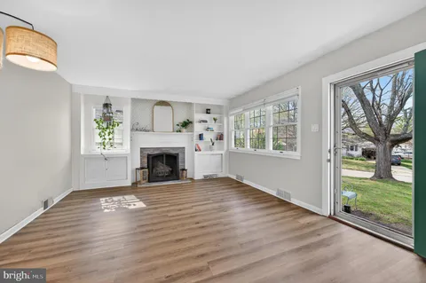 a view of an empty room with a window and fireplace