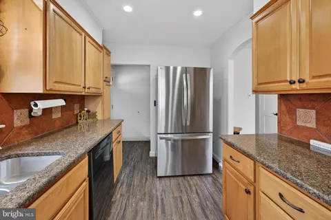 a kitchen with kitchen island granite countertop a sink appliances cabinets and counter space