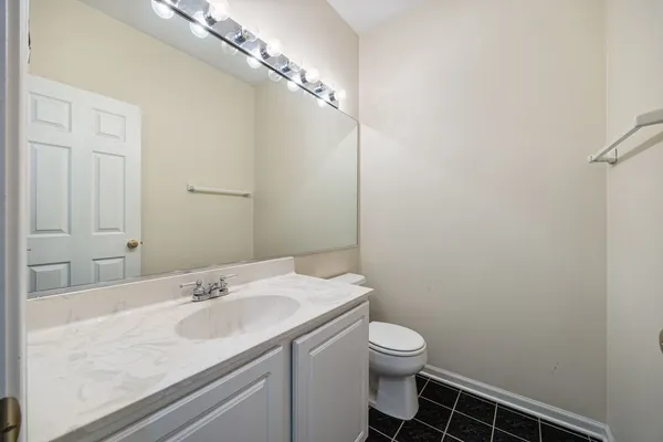 a bathroom with a granite countertop sink a toilet and a mirror