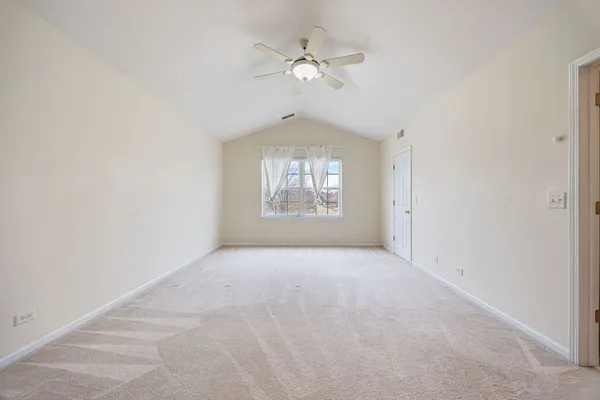 an empty room with a window and a ceiling fan