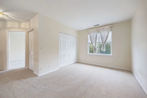 an empty room with windows and closet