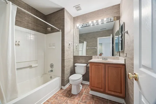 a bathroom with a toilet a sink and a large mirror