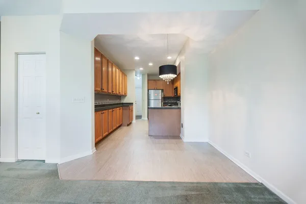 a view of a kitchen with wooden floor and a refrigerator