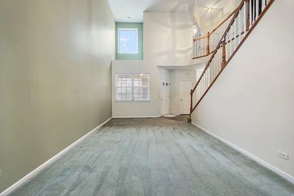 a view of an empty room with stairs and a window