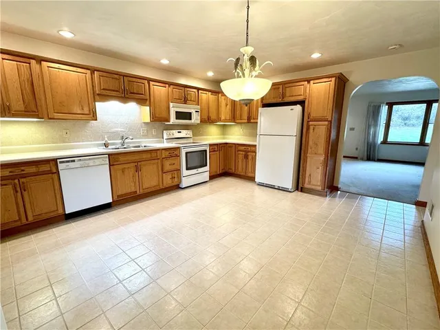 a large kitchen with cabinets and wooden floor