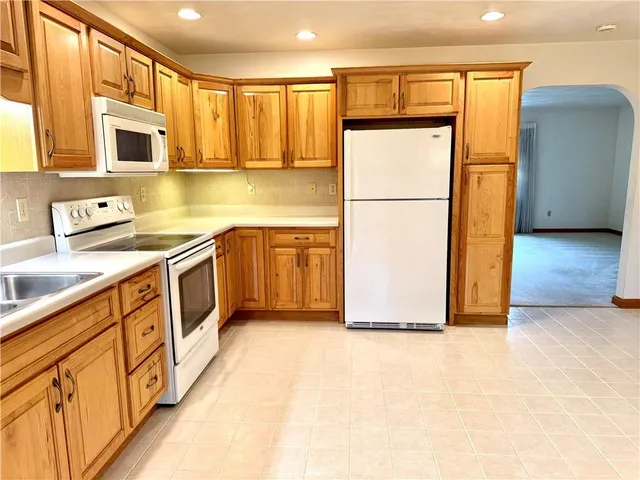 a kitchen with stainless steel appliances granite countertop a refrigerator a stove a sink and a microwave