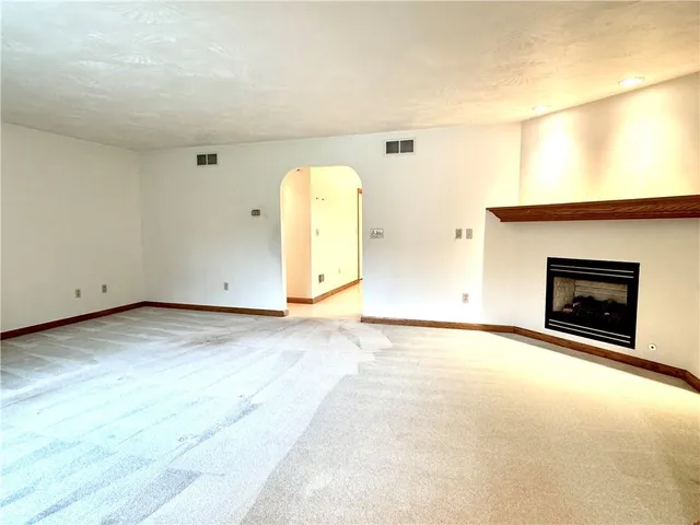an empty room with a fireplace and a window