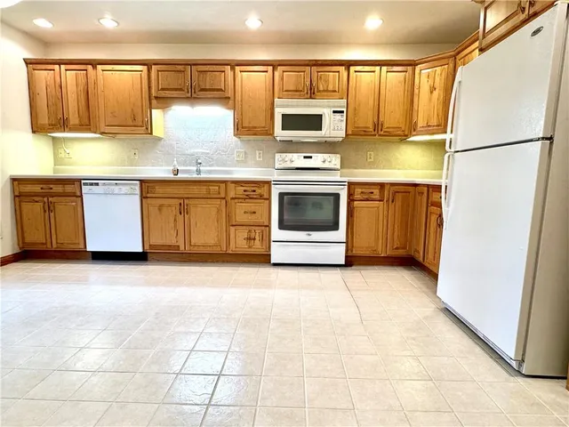 a kitchen with a white stove top oven and refrigerator