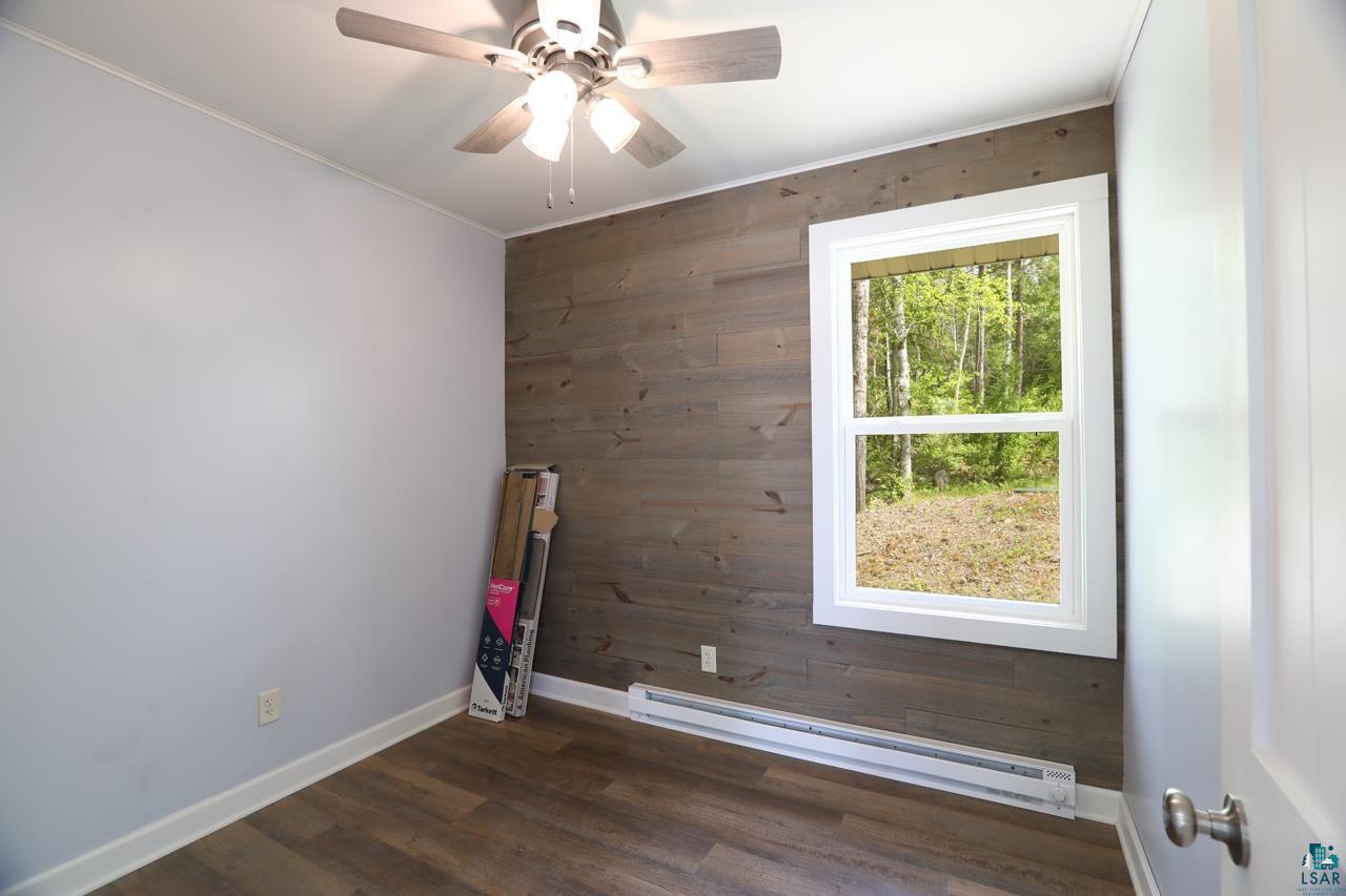3739 Sundling Road Tower, MN 55790 - Photo 4 of 15 Unfurnished room with plenty of natural light, ceiling fan, dark hardwood / wood-style flooring, and baseboard heating
