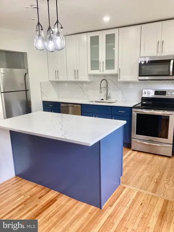 a kitchen with stainless steel appliances a stove a sink and a microwave