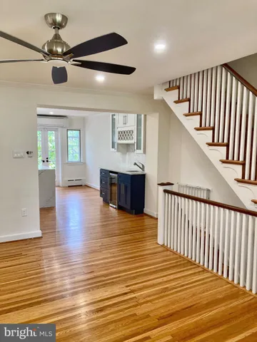 a view of a livingroom with wooden floor and a ceiling fan