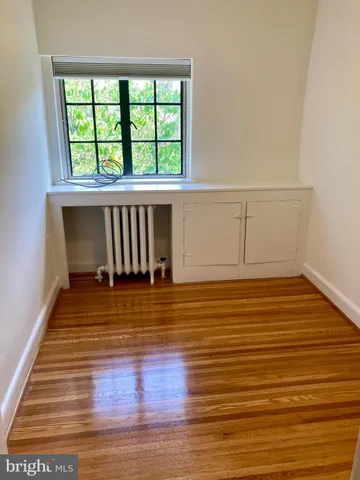 a view of a room with wooden floor and a window