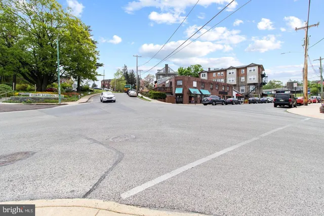 a city view with tall buildings and cars parked on road