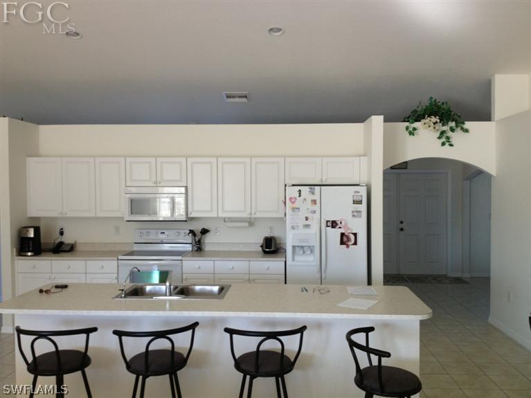 6022 Stratton Road Fort Myers, FL 33905 - Photo 1 of 5 a kitchen with stainless steel appliances a table and chairs in it
