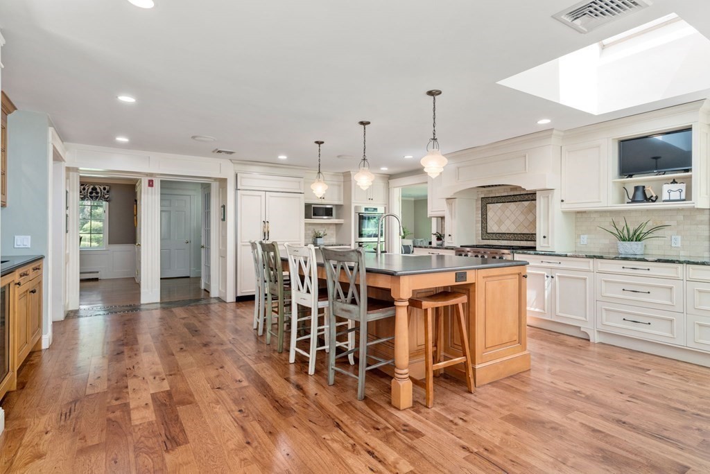 5 Deerfield Road Sherborn, MA 01770 - Photo 8 of 42 a kitchen with stainless steel appliances kitchen island granite countertop a table chairs sink and cabinets