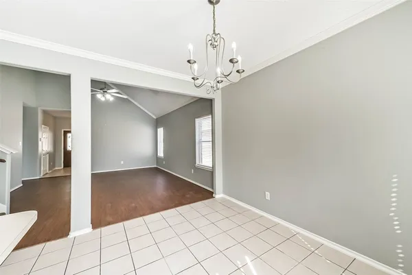 wooden floor in an empty room with a chandelier