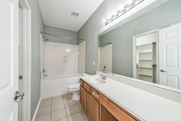 a bathroom with a double vanity sink toilet mirror and bathtub