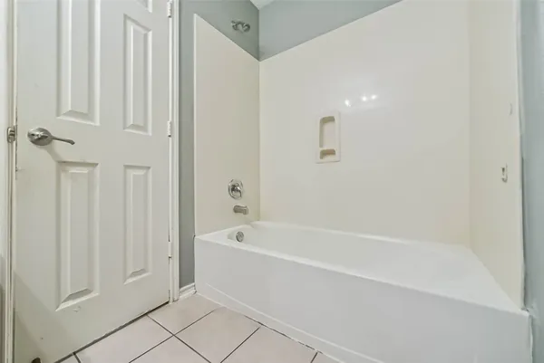 a white bath tub sitting next to a shower