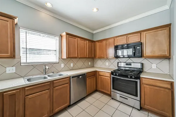 a kitchen with sink a microwave and cabinets