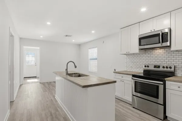 a kitchen that has a sink and a stove top oven
