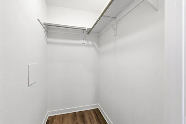 a view of walk in closet with empty racks