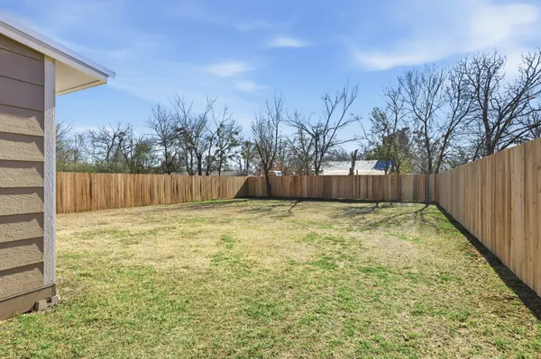a view of a backyard with wooden fence