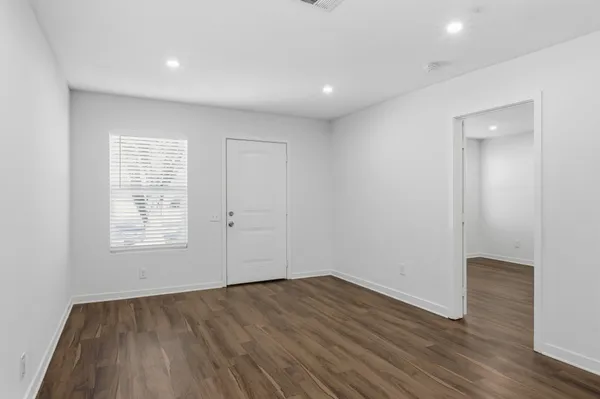 an empty room with wooden floor and window