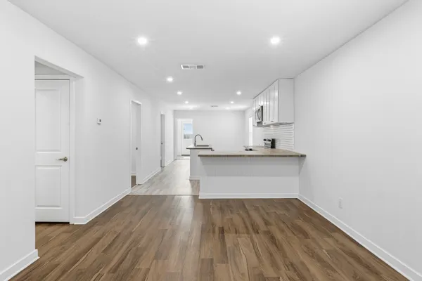 a view of kitchen with wooden floor and electronic appliances