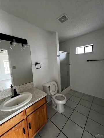 a spacious bathroom with a granite countertop sink a toilet and a mirror