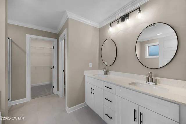 a en suite bathroom with a double vanity sink and a mirror