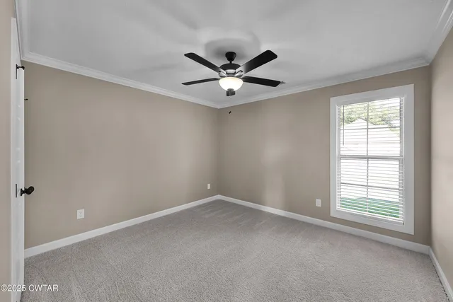 an empty room with a window and a ceiling fan