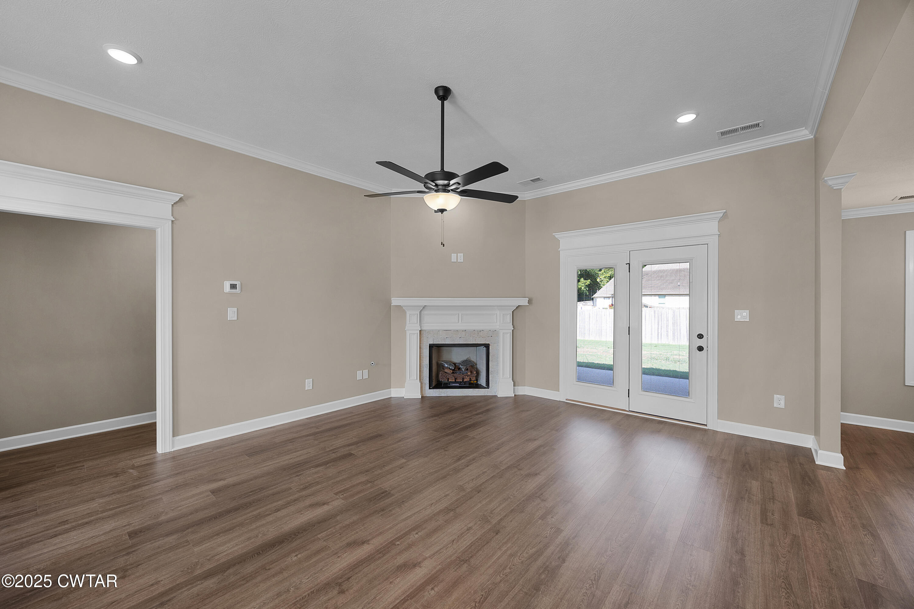 116 Garrison Drive Jackson, TN 38305 - Photo 3 of 18 a view of a livingroom with wooden floor a fireplace a ceiling fan and windows