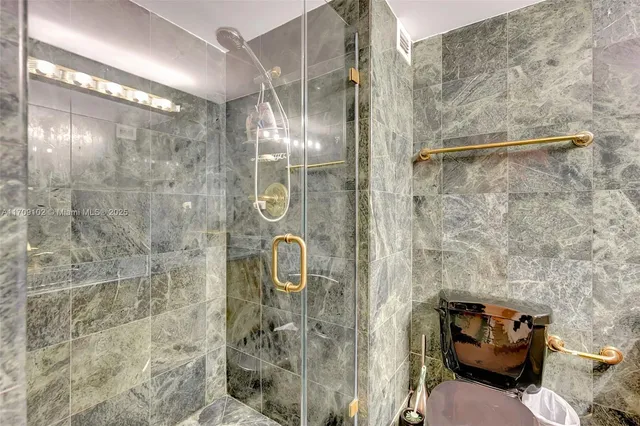 a bathroom with a granite countertop sink a toilet and shower