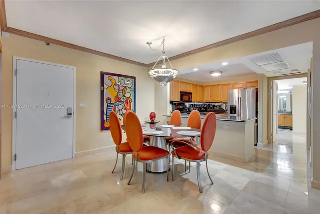 a kitchen with stainless steel appliances granite countertop a kitchen island a stove a dining table and chairs