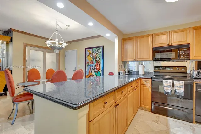 a kitchen with stainless steel appliances granite countertop a sink refrigerator and cabinets