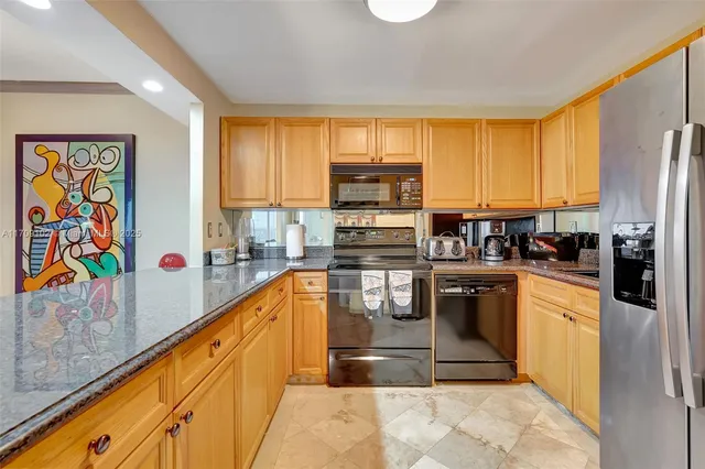 a kitchen with granite countertop stainless steel appliances sink and microwave