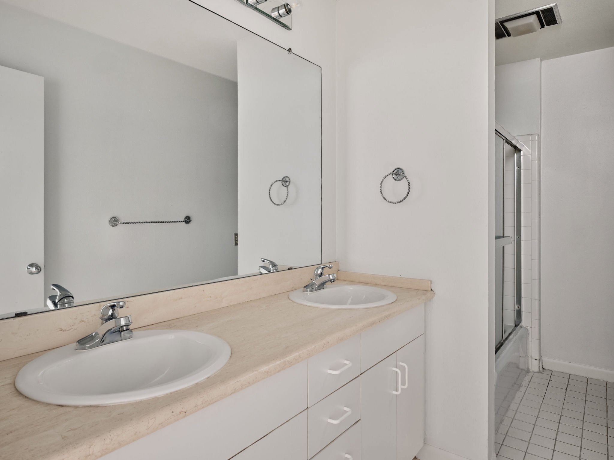 3416 Pecos Street, Unit B Austin, TX 78703 - Photo 18 of 23 Bathroom with double vanity, light tile patterned flooring, and shower / bath combination with glass door