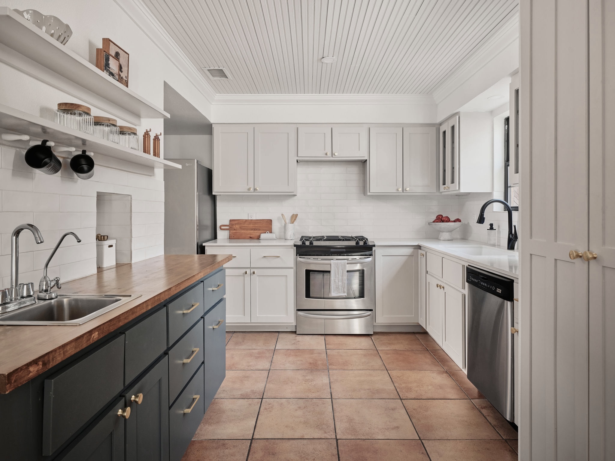 3416 Pecos Street, Unit B Austin, TX 78703 - Photo 4 of 23 Kitchen featuring stainless steel appliances, open shelves, butcher block counters, two tone cabinetry, and light tile patterned floors
