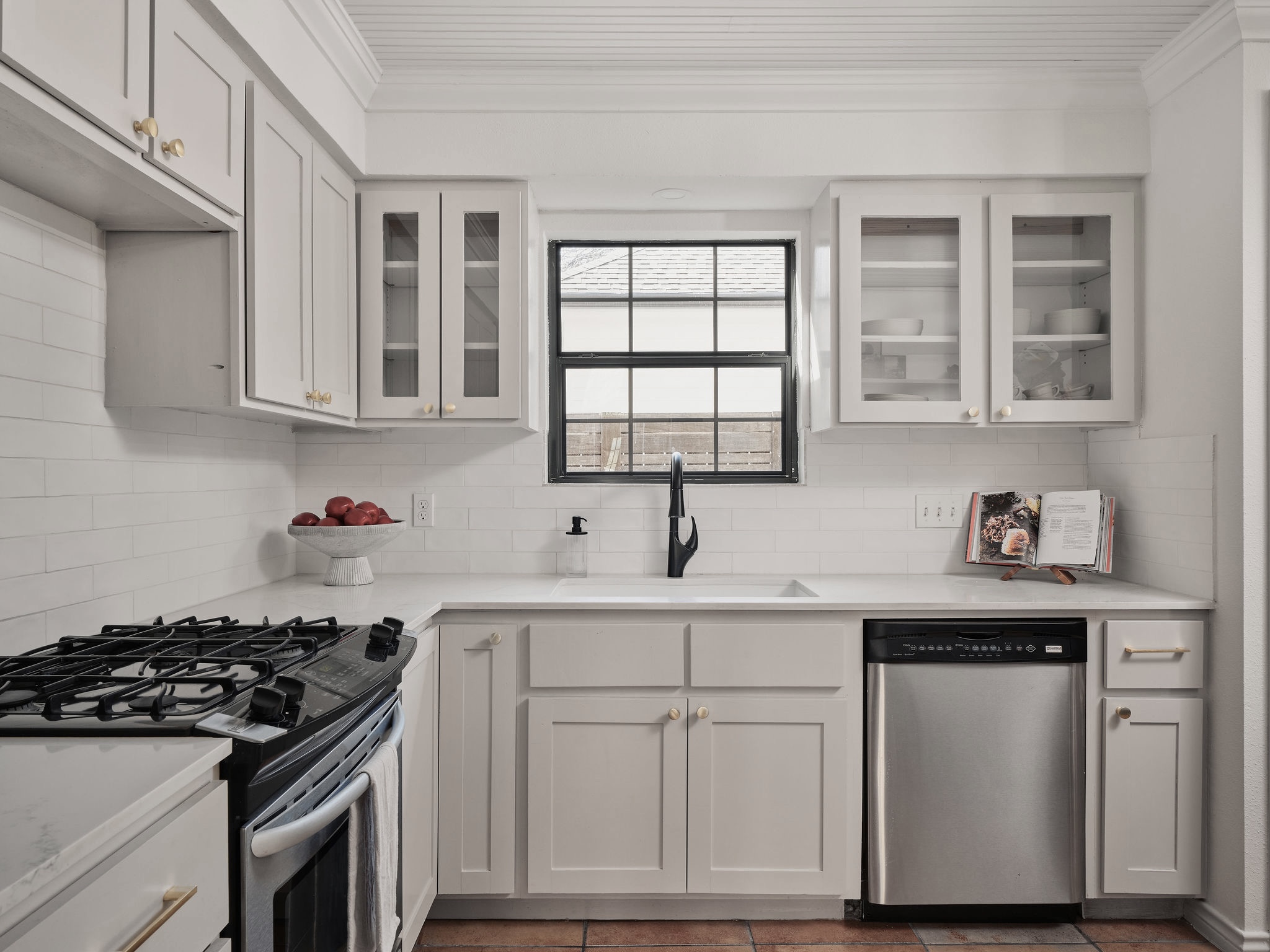 3416 Pecos Street, Unit B Austin, TX 78703 - Photo 5 of 23 Kitchen featuring stainless steel appliances, glass fronted cabinets, white cabinets, crown molding, and tile patterned flooring