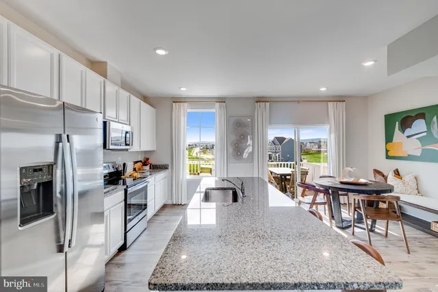 a large kitchen with stainless steel appliances lots of counter space and furniture